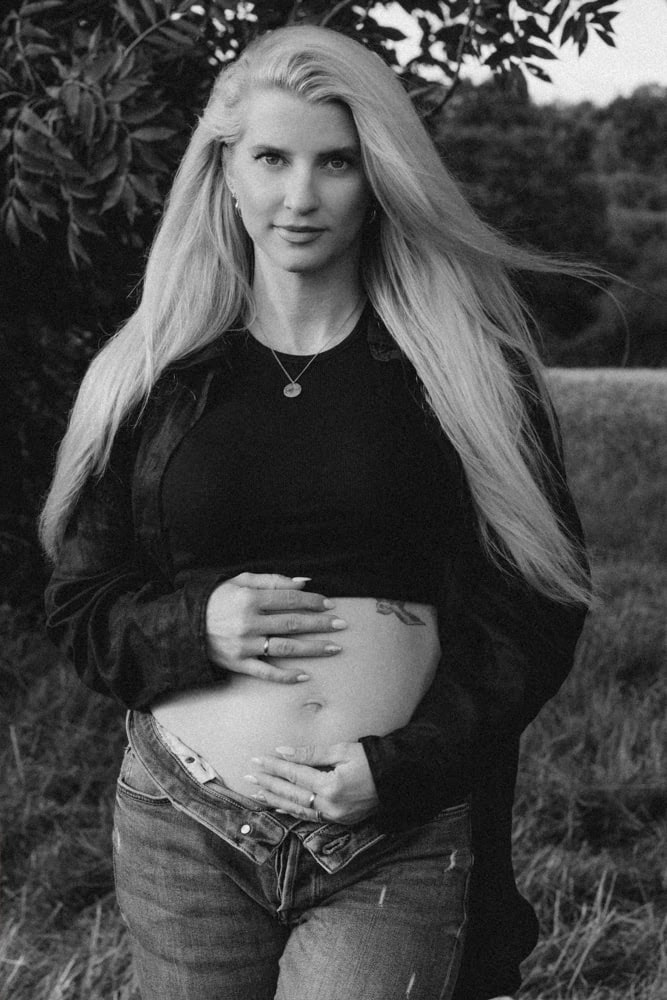 Veronika Haas zeigt ihren Babybauch bei einem Babybauch-Shooting im Freien.