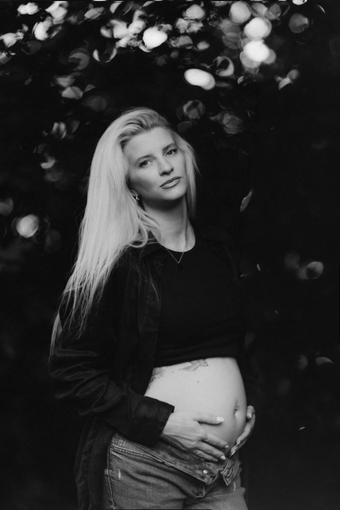 Schwangere Frau mit Babybauch bei Babybauch Shooting, schwarz-weiß.