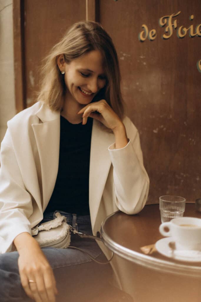 Veronika Haas lächelt beim Paarshooting in einem gemütlichen Café, entspannt und glücklich.