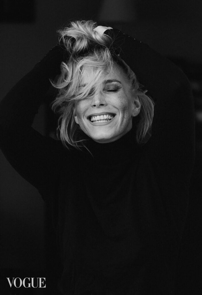 Veronika Haas in einem schwarzen Pullover, lachend und mit lockigem, blondem Haar, bei einem Portrai.