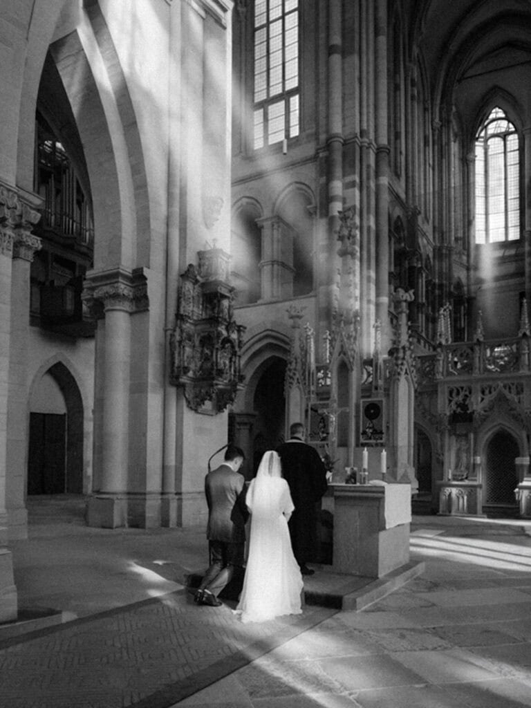Veronika Haas im Magdeburger Dom, elegante Hochzeitsszene, Innenraum, Lichtstrahlen, romantisch.