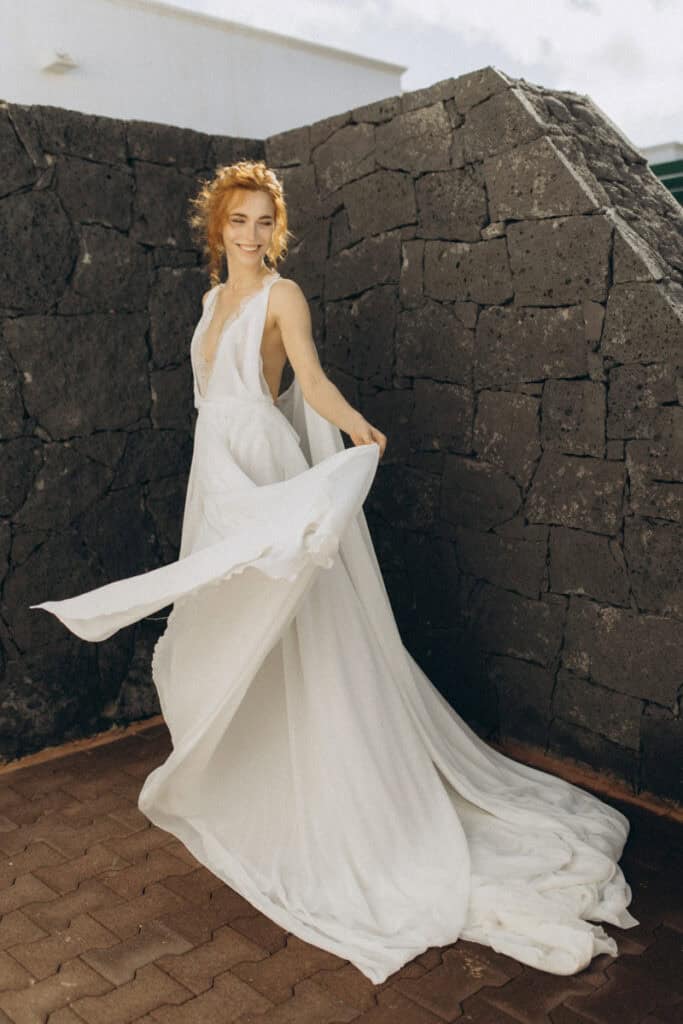 Veronika Haas in einem weißen Brautkleid am Strand von Lanzarote, perfekt für intime Hochzeitsmoment.