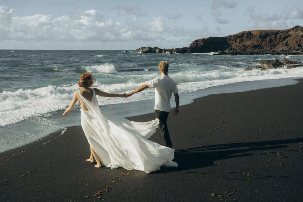 Veronika Haas beim intimen Strandengagement auf Lanzarote, umgeben von schwarzem Sand und atemberaub.