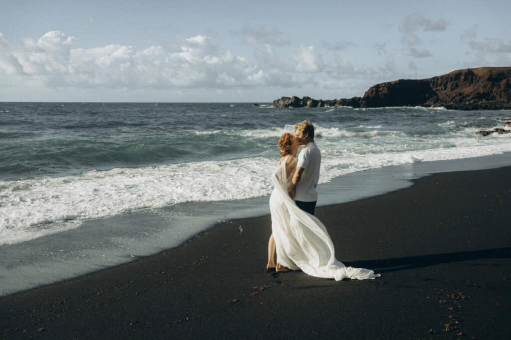 Veronika Haas beim intimen Engagement am schwarzen Sandstrand von Lanzarote, umgeben von Meer und Na.