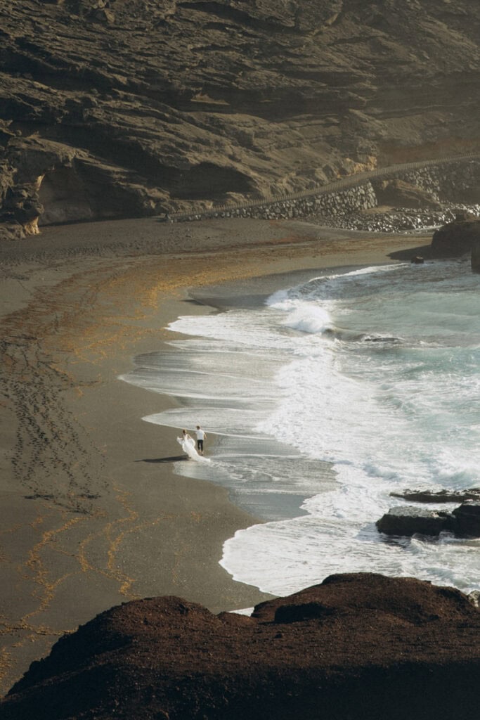 Veronika Haas am Strand während eines intimen Engagements auf Lanzarote, umgeben von dramatischer Kü.