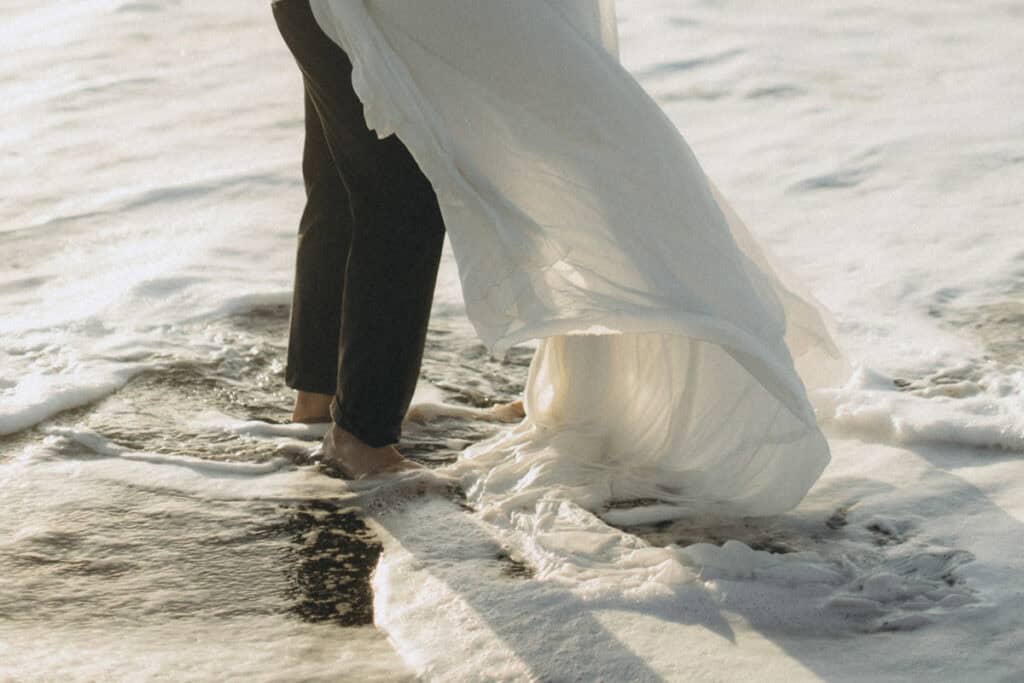 Veronika Haas im weißen Brautkleid am Strand von Lanzarote, bei einem intimen Engagement-Fotoshootin.
