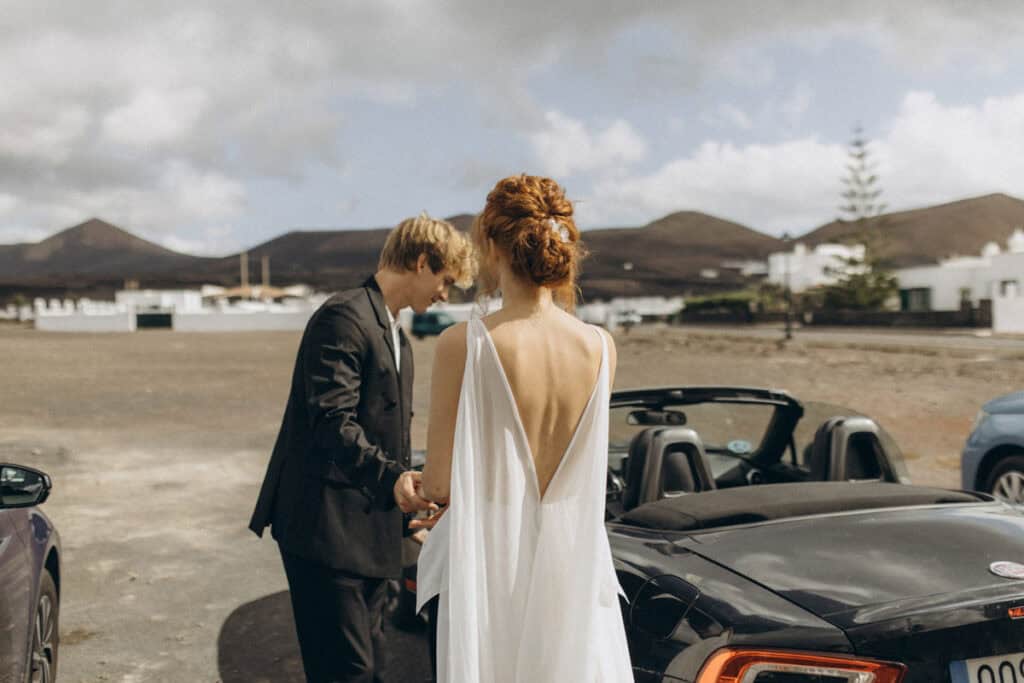 Veronika Haas bei intimer Strandverlobung auf Lanzarote, umgeben von Bergen und weißen Häusern.