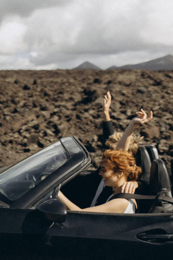 Veronika Haas im Cabrio am Strand von Lanzarote, entspannt und glücklich.