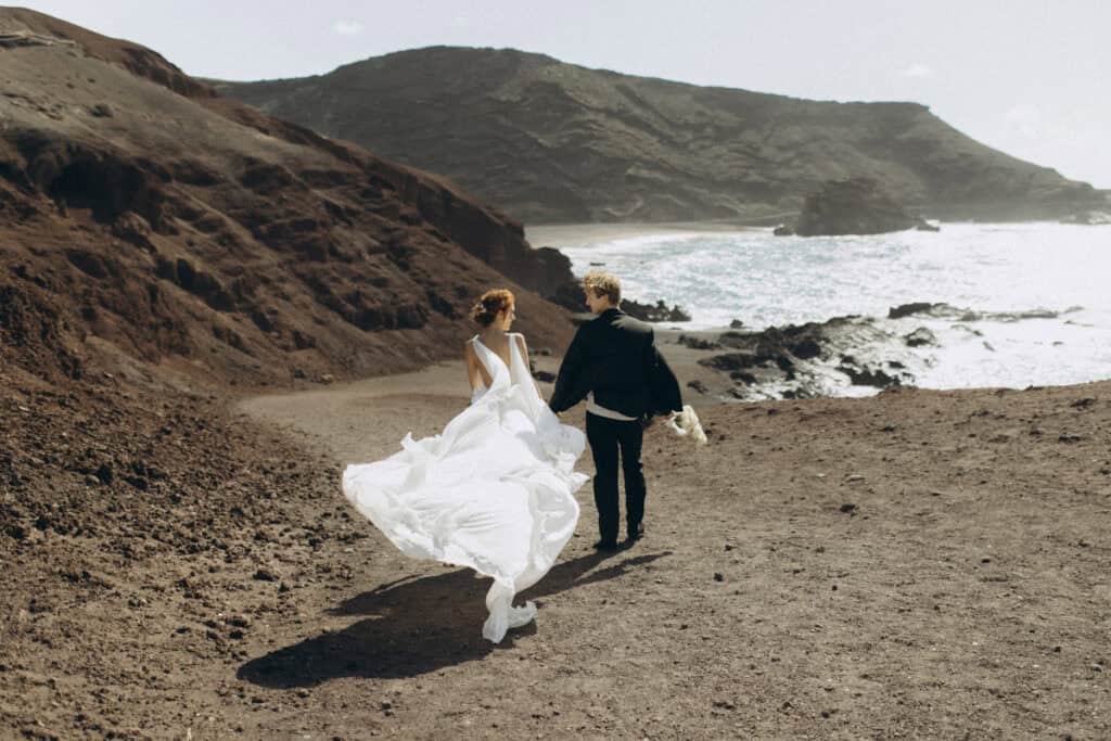 Veronika Haas beim intimen Strand-Engagement auf Lanzarote, mit Blick auf das Meer und die vulkanisc.