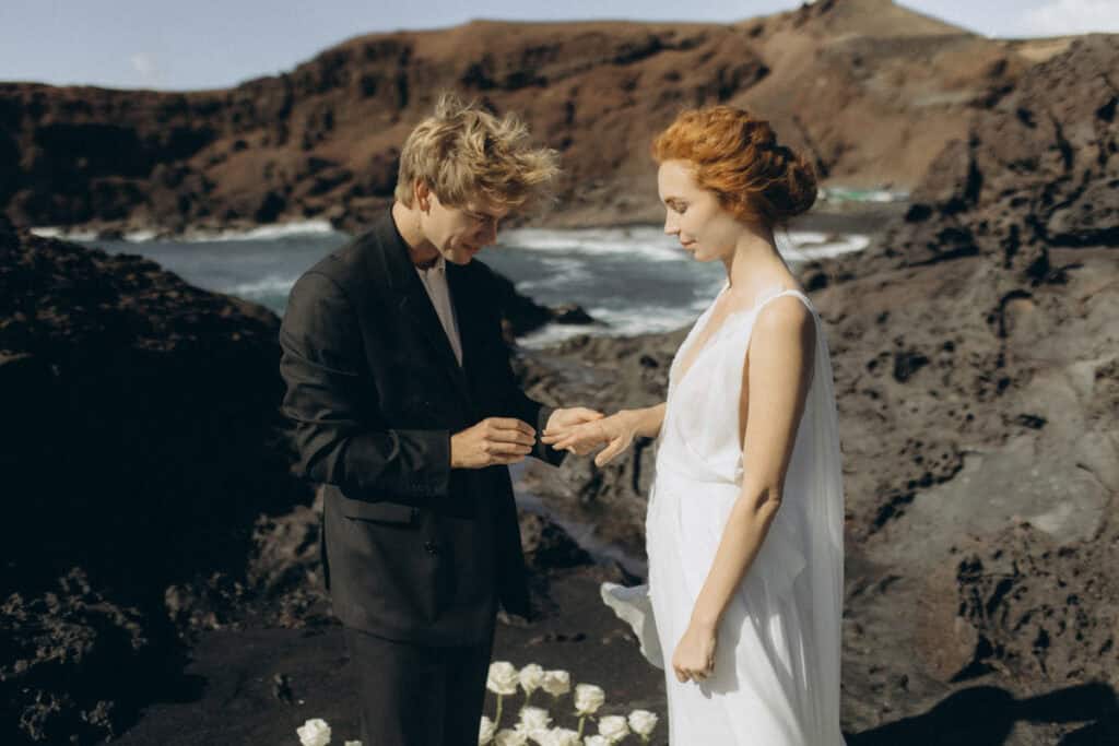 Veronika Haas bei einer romantischen Strandhochzeit auf Lanzarote, umgeben von Vulkanlandschaft.