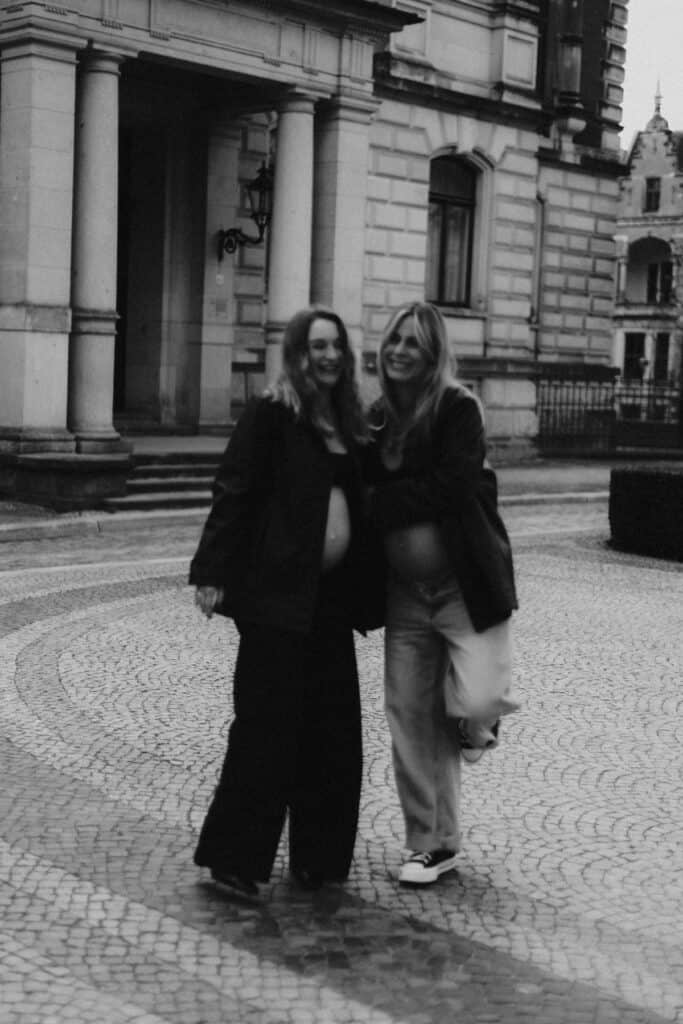 Veronika Haas bei Babybauch-Fotoshooting vor historischem Gebäude, strahlend und glücklich.